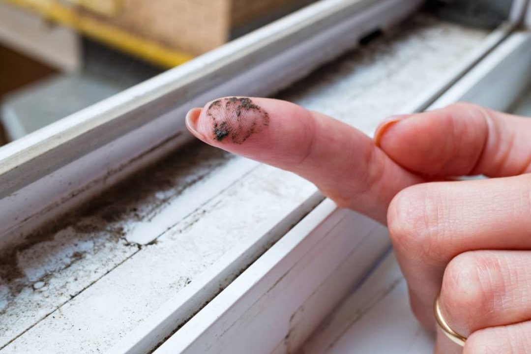 A dirty finger with dirt showing the need for cleaning the house, washing PVC window frames. Cleaning concept.